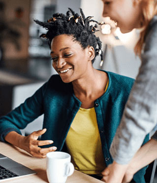 Two women in an office, working together.