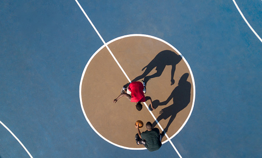 Vue du dessus : deux jeunes hommes en train de jouer au basket.